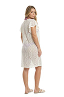 A woman modeling a short-sleeve white crochet lace nightgown with a geometric diamond pattern, shown from a three-quarters back view against a solid white background.