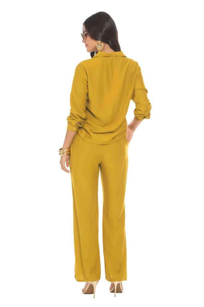 Woman wearing a mustard yellow outfit on a white background