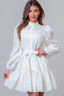 Woman wearing a white lace dress with long sleeves on a gray background