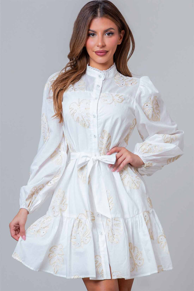 Woman wearing a white lace dress with long sleeves on a gray background