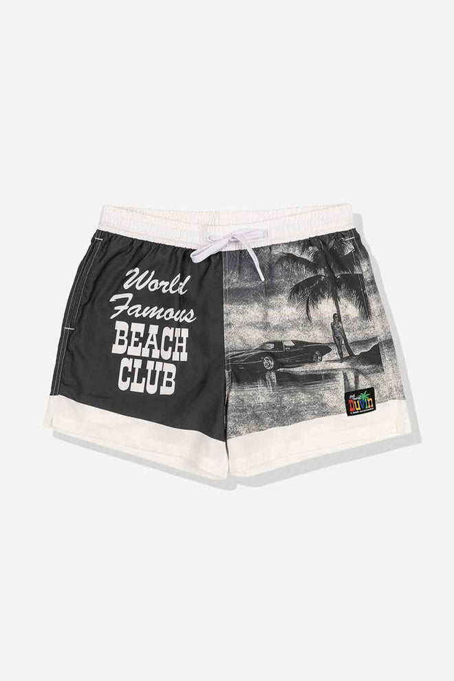 Black and white shorts with 'World Famous Beach Club' text and tropical graphic on a light gray background