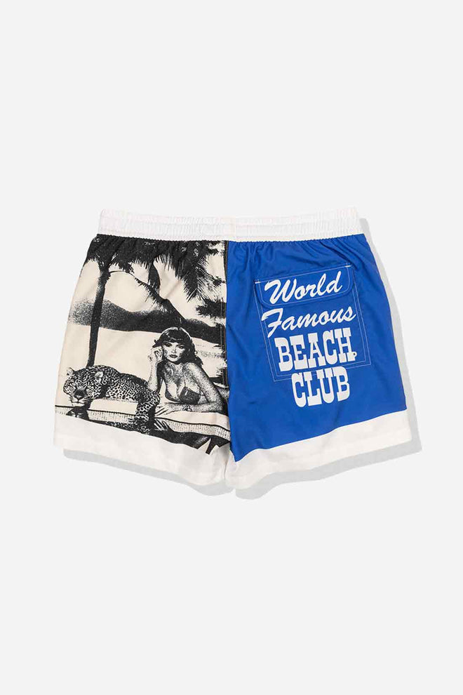 Shorts with a vintage-style design featuring a woman, leopard, and palm trees on one side, and 'World Famous Beach Club' text on the other, against a white background.