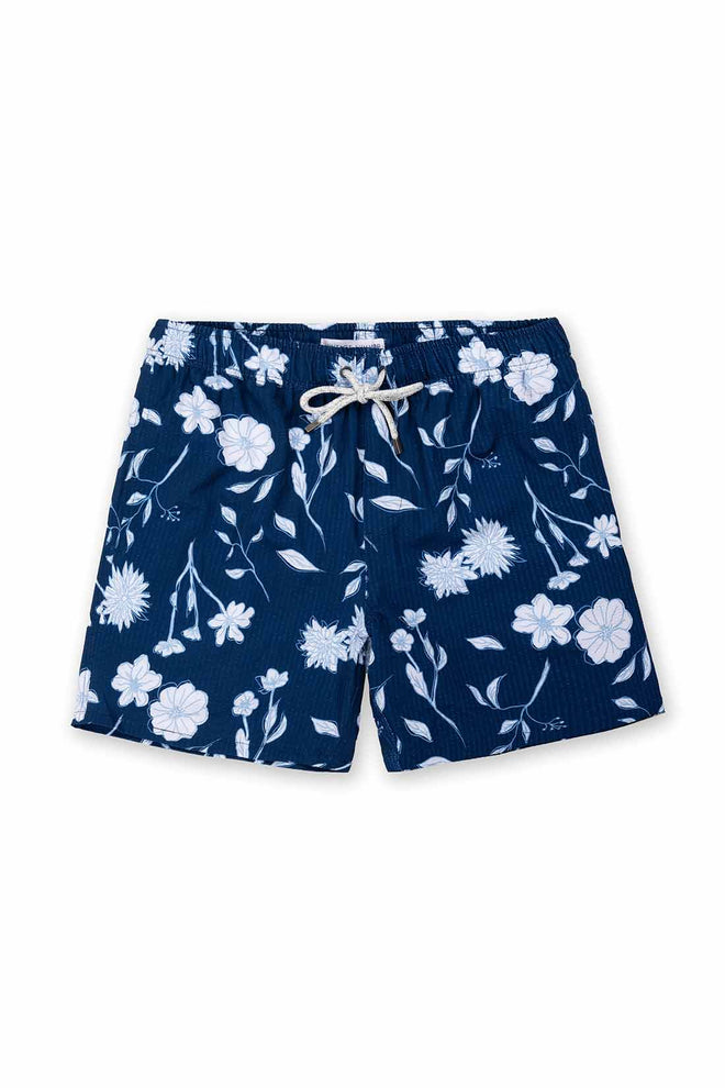 Navy blue swim shorts with white floral pattern on a white background